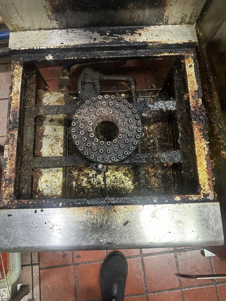 Grease buildup on a commercial stockpot burner before cleaning